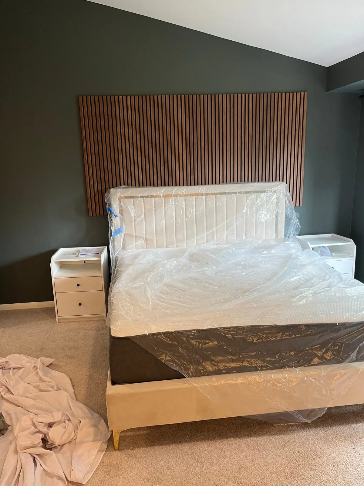 Wood-slat accent wall installed behind the bed